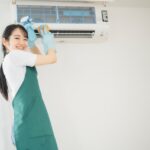 エアコン掃除している女性の画像